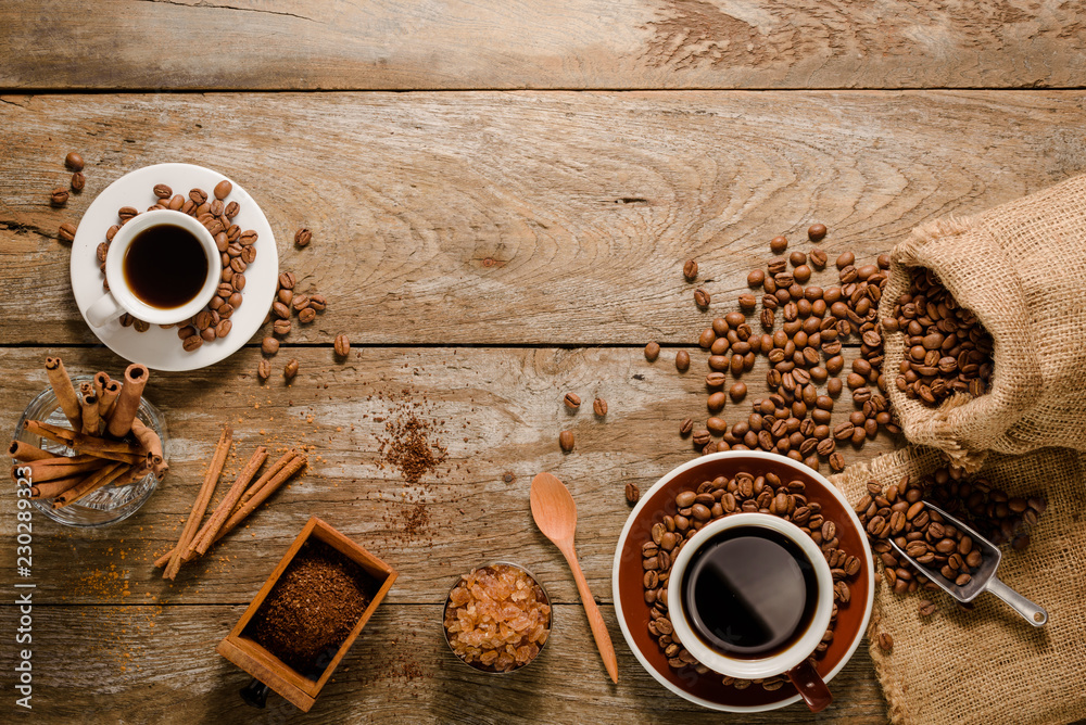 Top view of a cup of americano with coffee bean bag, sugar and cinnamon on wood background floor