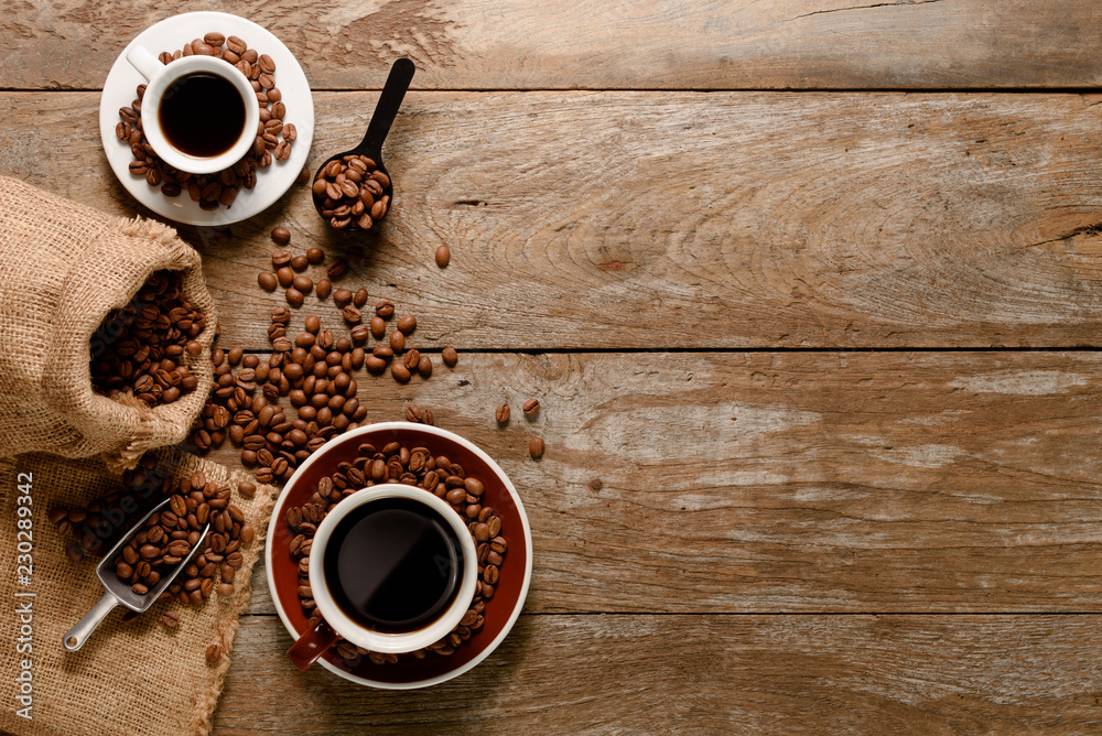 一杯美式咖啡的俯视图，木质背景地板上有咖啡豆袋、糖和肉桂