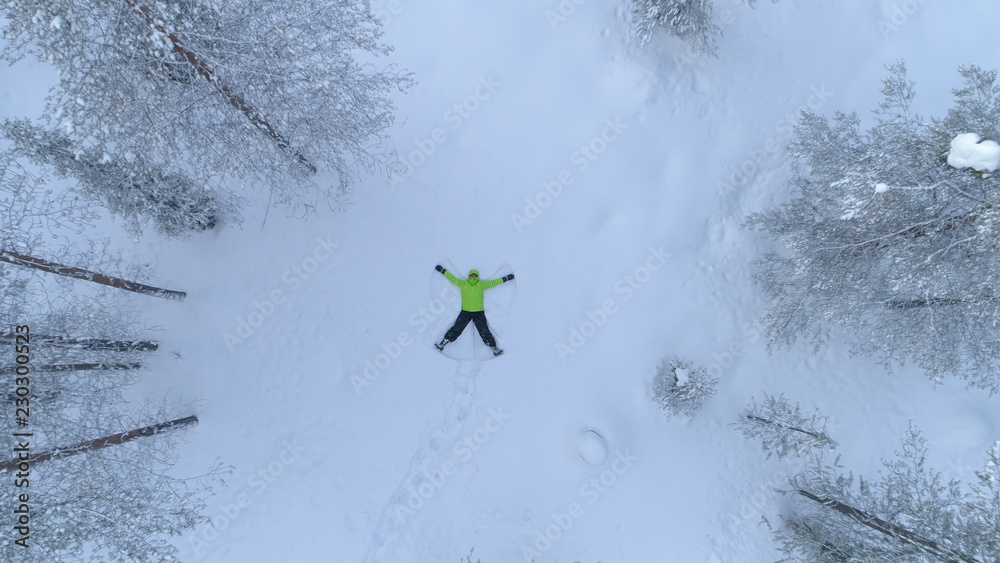 空中俯视：快乐的女孩在新鲜的雪地冬季森林中形成雪角