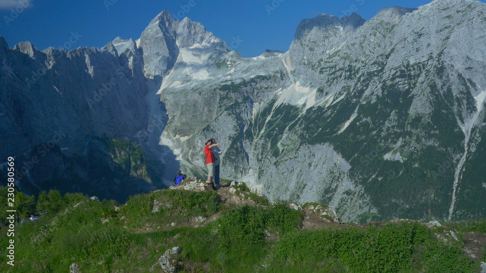 航空：一个兴高采烈的男人向他的女朋友展示壮观的斯洛文尼亚山脉。