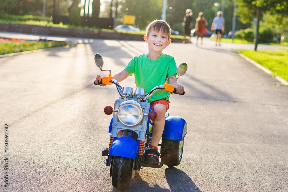 男孩骑着一辆儿童电动摩托车