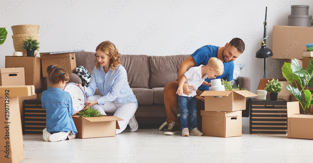 幸福家庭母亲、父亲和孩子搬到新公寓并打开箱子