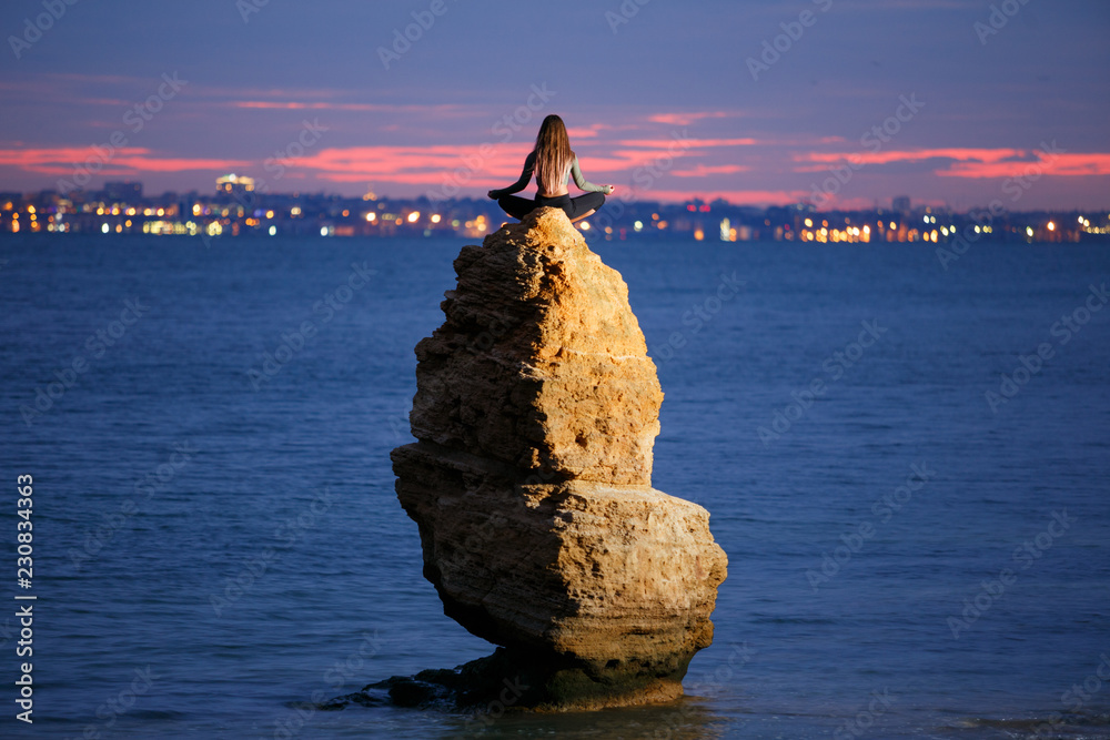 坐在岩石上的瑜伽女孩