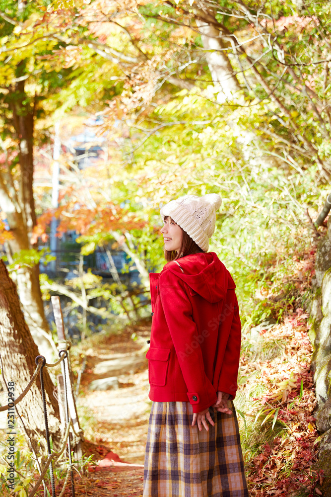 秋の紅葉の中の女性　笑顔