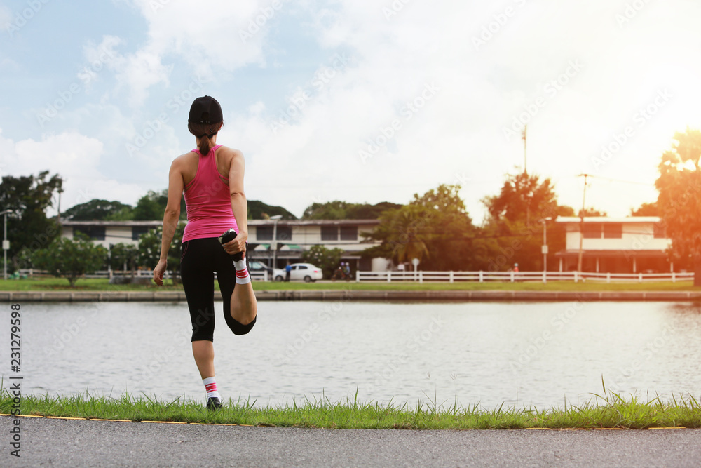 运动型女性在城市锻炼前做晨拉伸和热身运动