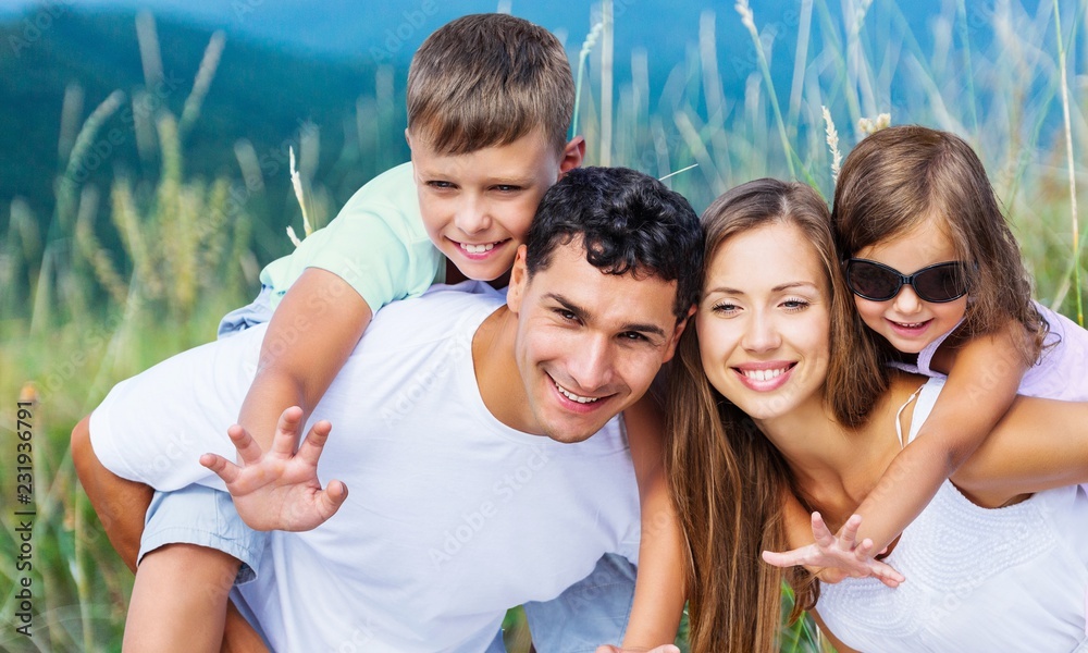 Happy family enjoying vacations otdoors with blurred field on