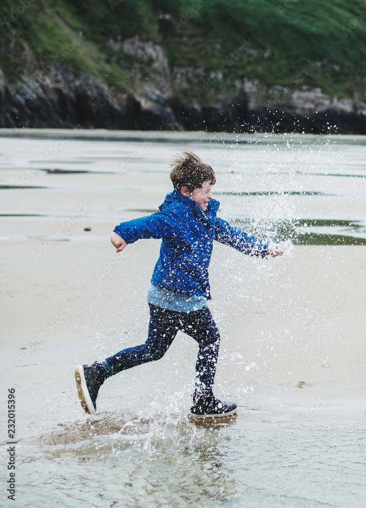 快乐的男孩在海滩上奔跑
