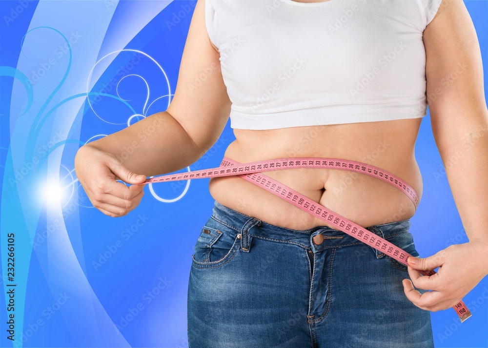 超重的胖女人在后台测量自己的肚子