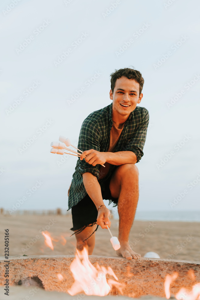 男人在篝火上烤棉花糖