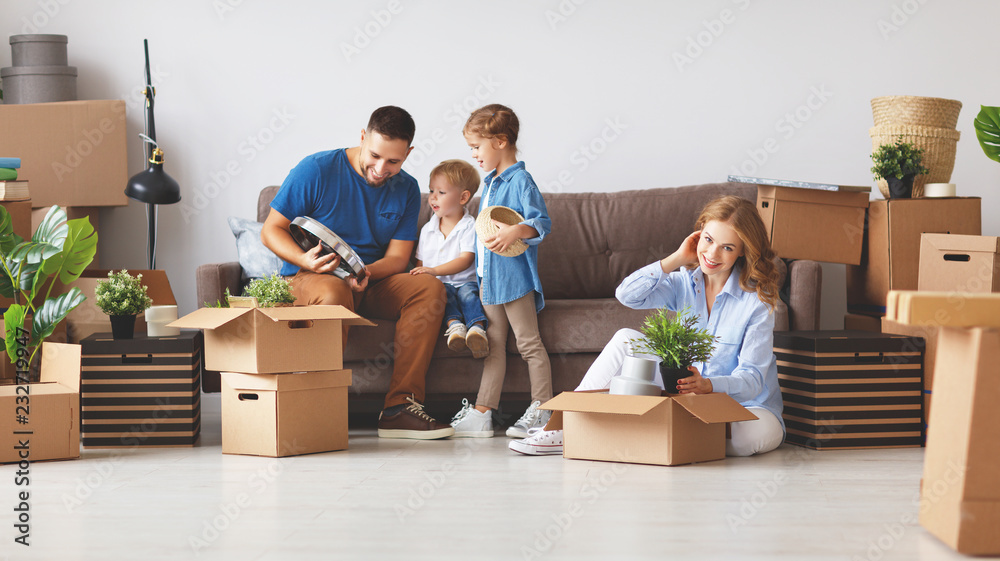 幸福家庭母亲、父亲和孩子搬到新公寓并打开箱子