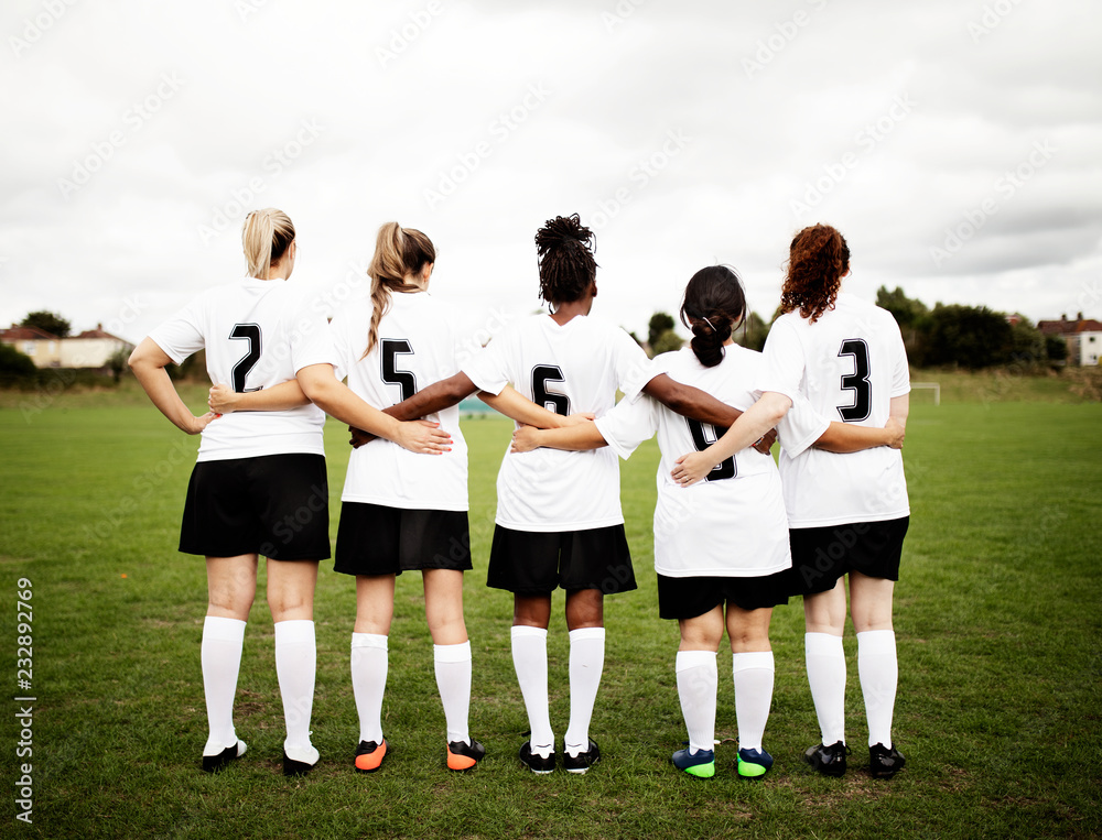 女性足球运动员挤在一起，站在一起