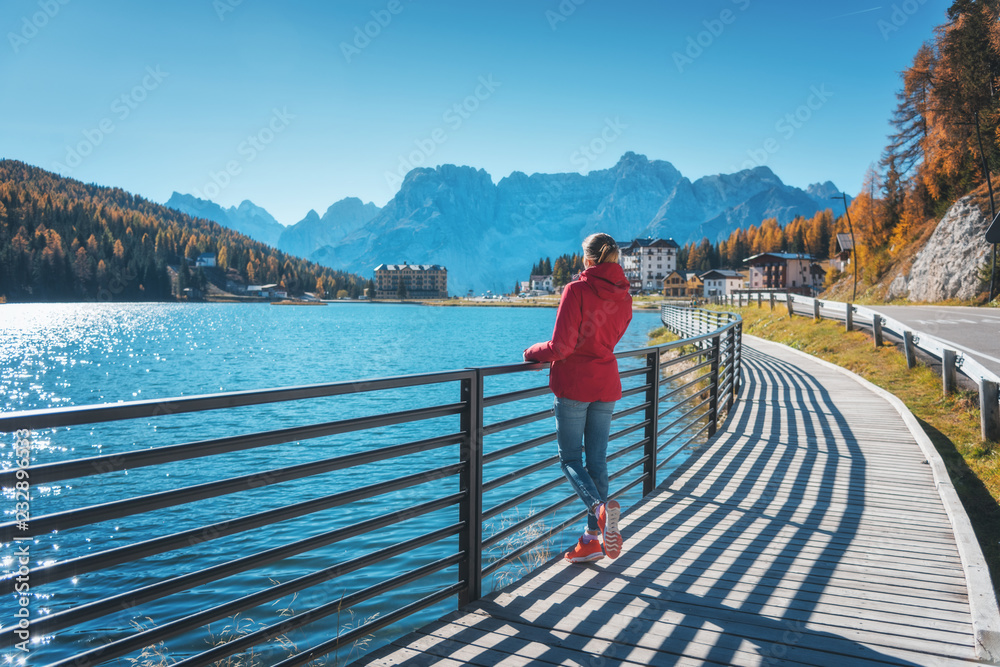 秋天日出时，一名年轻女子站在米苏里纳湖畔。意大利多洛米蒂。风景