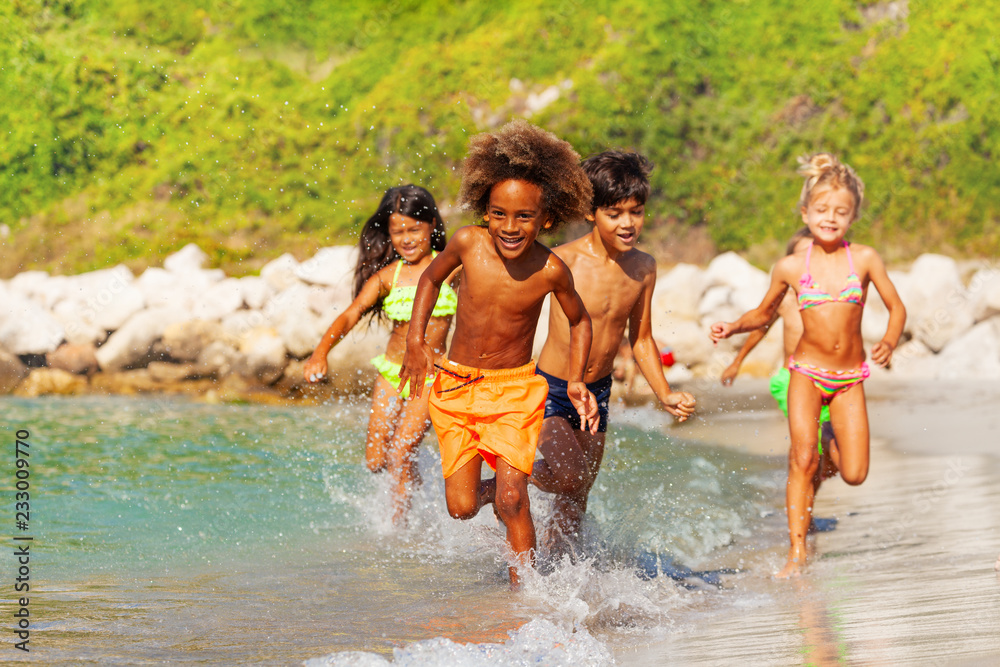 快乐的多民族孩子在海边玩得开心
