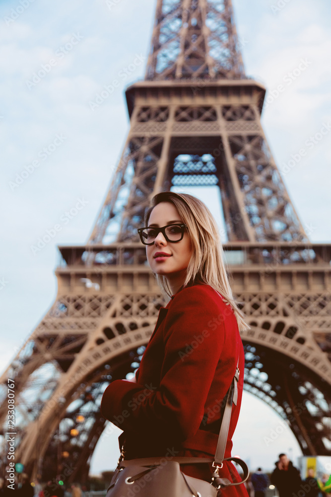 秋天，巴黎街上穿着红色外套和包包的红发女孩，可以看到埃菲尔铁塔