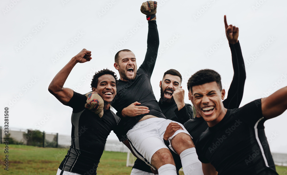 足球运动员举起队友庆祝胜利