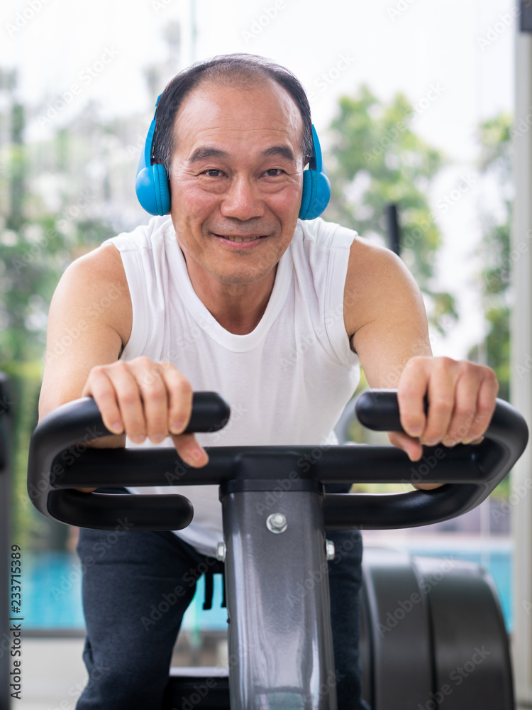 老年人在健身中心骑自行车锻炼。成熟健康的生活方式。