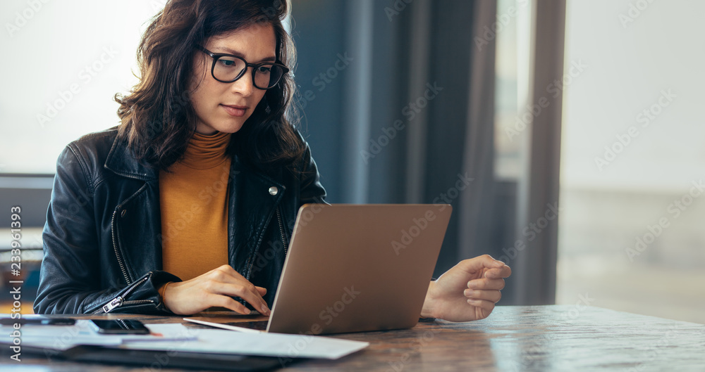 亚洲女性在办公室使用笔记本电脑