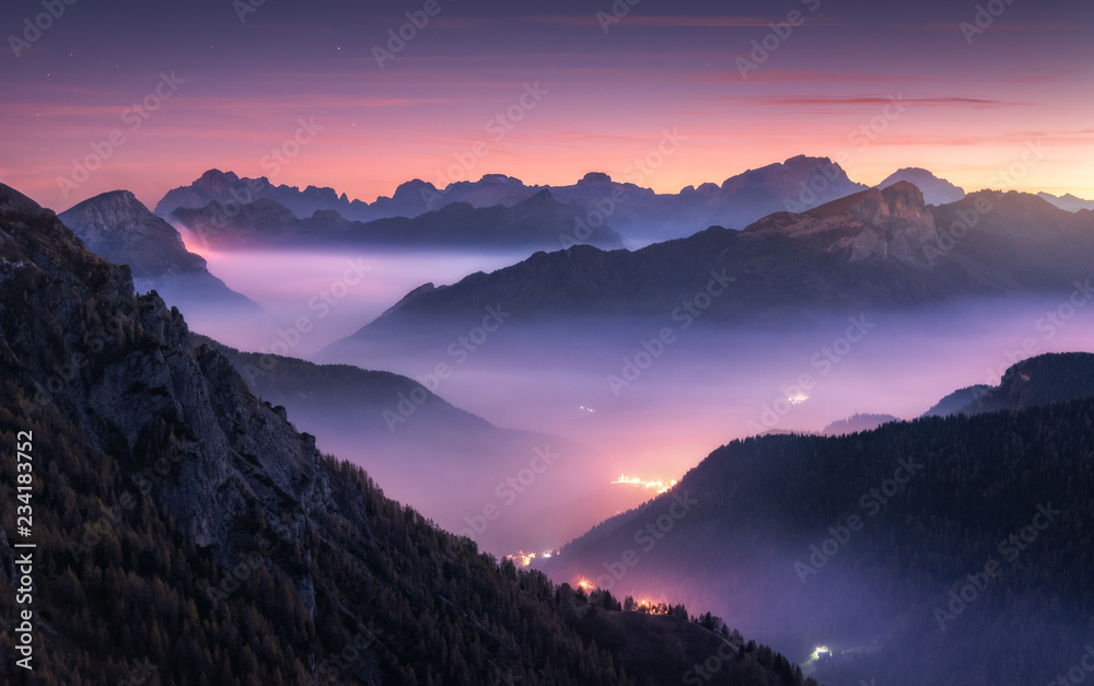 Mountains in fog at beautiful night in autumn in Dolomites