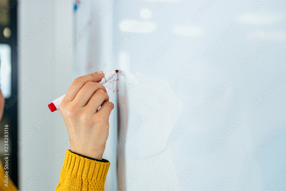 商业、人、思想和教育理念。女性在白板上写字。