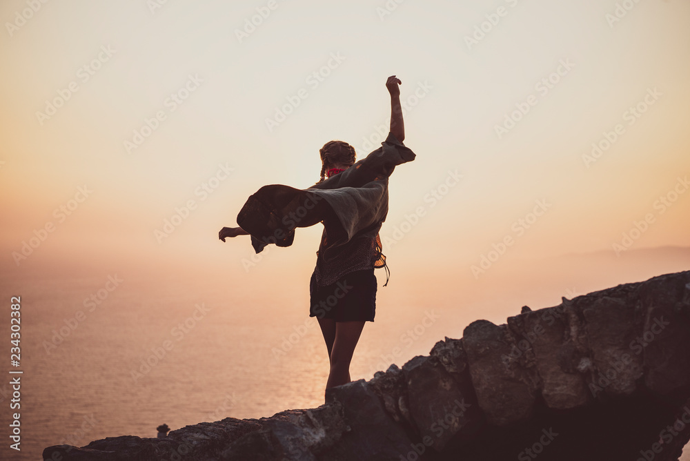 年轻苗条的女游客在希腊罗兹岛Monolithos城堡后面的石头上保持平衡