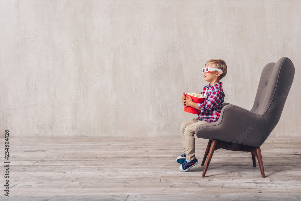 Little child in 3d glasses in a chair