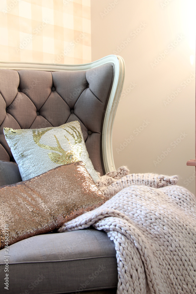 卧室里有格子壁纸的舒适的特色椅子，上面有厚实的针织毯子。