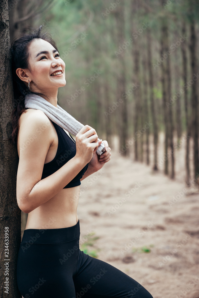 亚洲女孩周末在郁郁葱葱的松林中锻炼。运动女孩和李娜