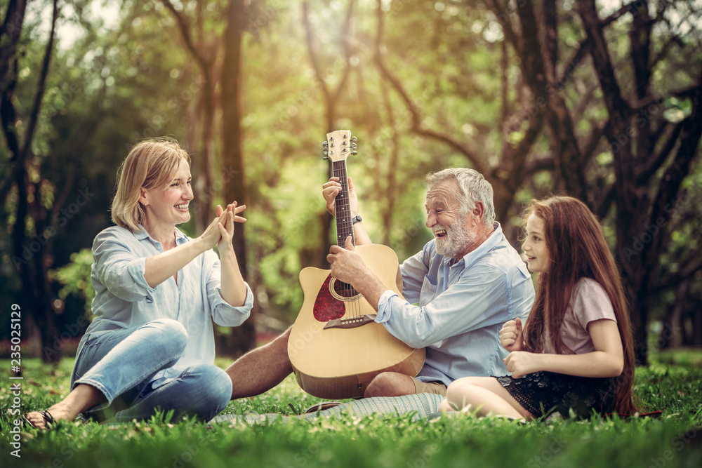 快乐的一家人在公园里一起弹吉他唱歌