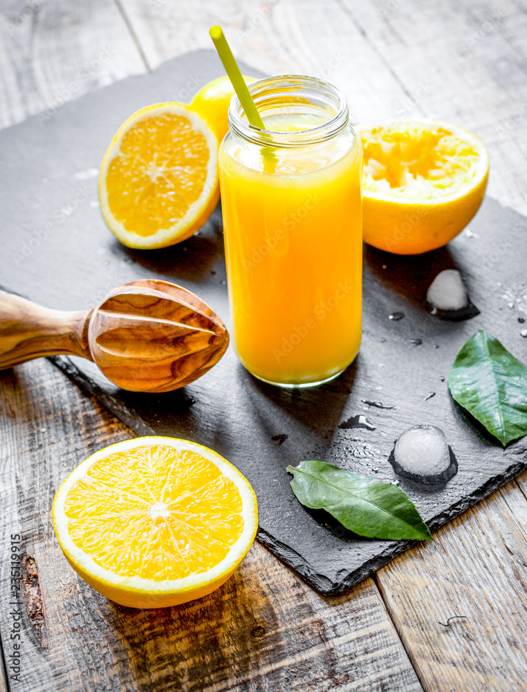 装在木制背板上的玻璃瓶中的鲜榨橙汁