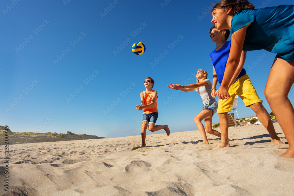 孩子们在海上度假时玩沙滩排球