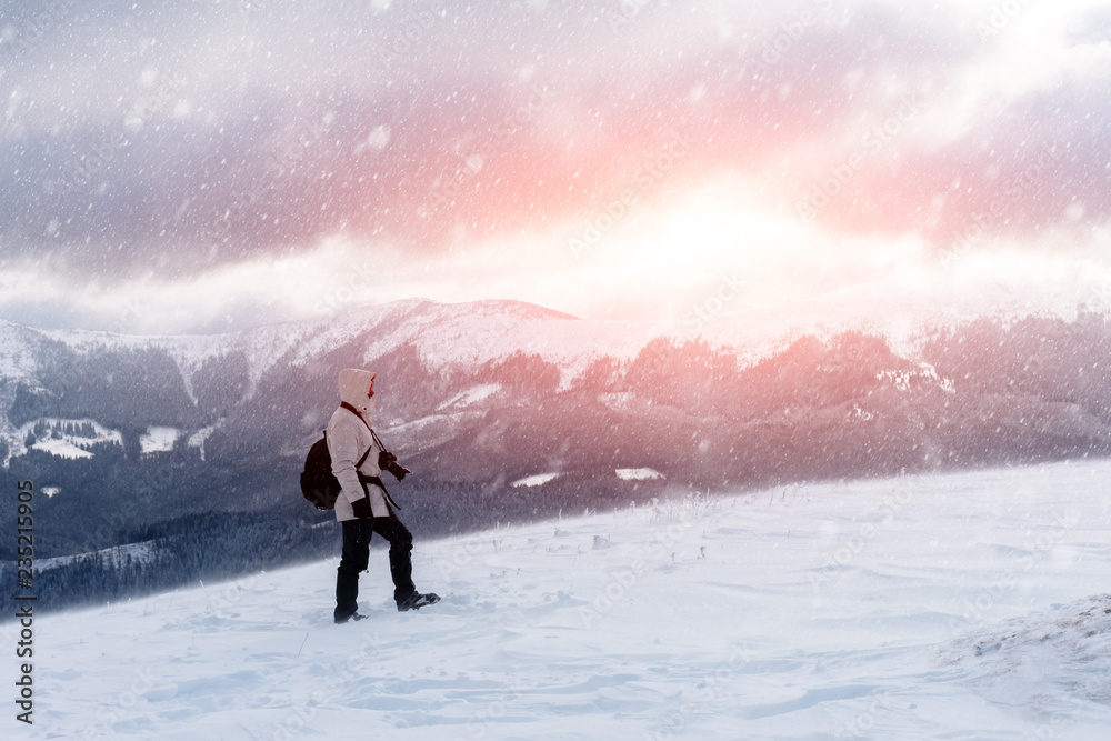 冬天独自一人背着背包在暴风雪中山顶拍摄。旅行理念。鲤鱼
