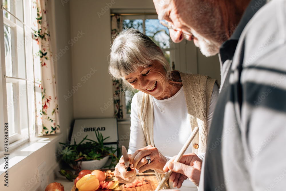 幸福的老年夫妇站在厨房里做食物