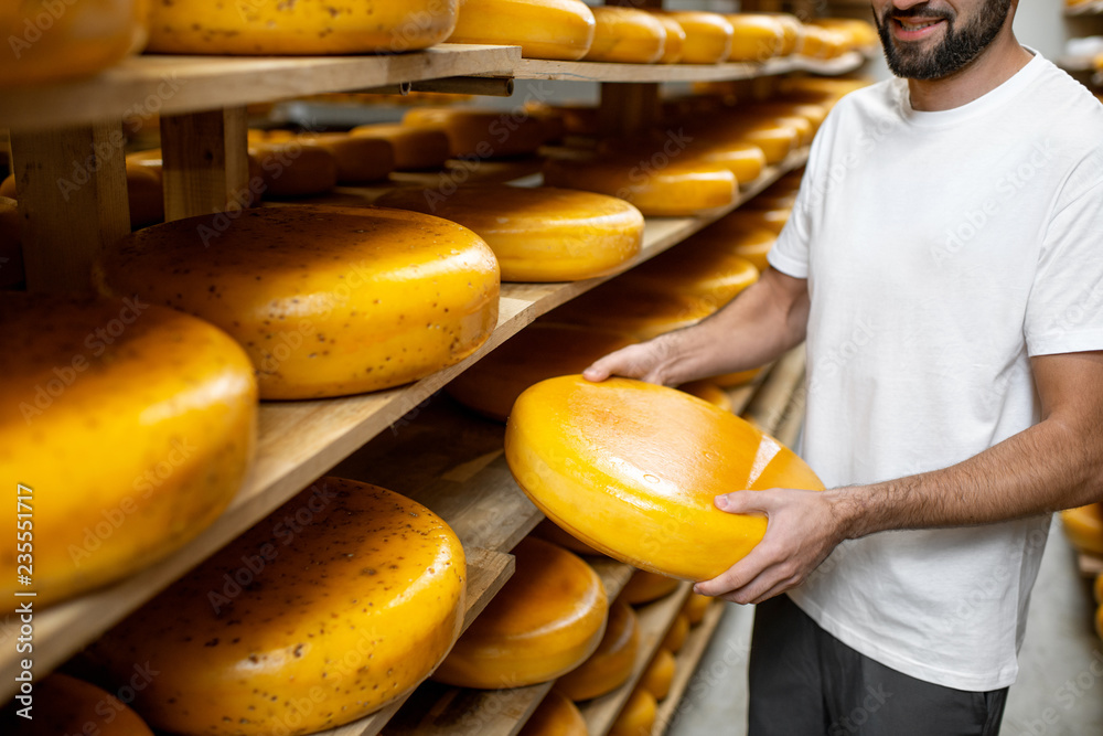 在奶酪陈化过程中，工人在仓库拿奶酪轮。无fac的特写