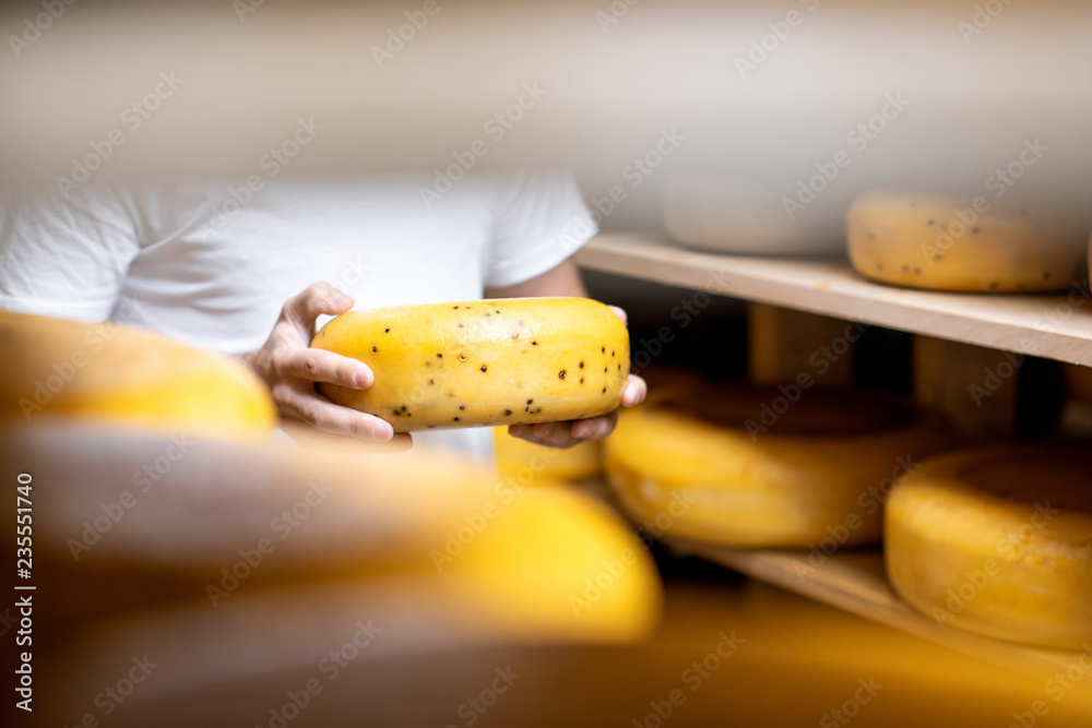 陈化过程中，将奶酪轮固定在奶酪储存处。无脸特写