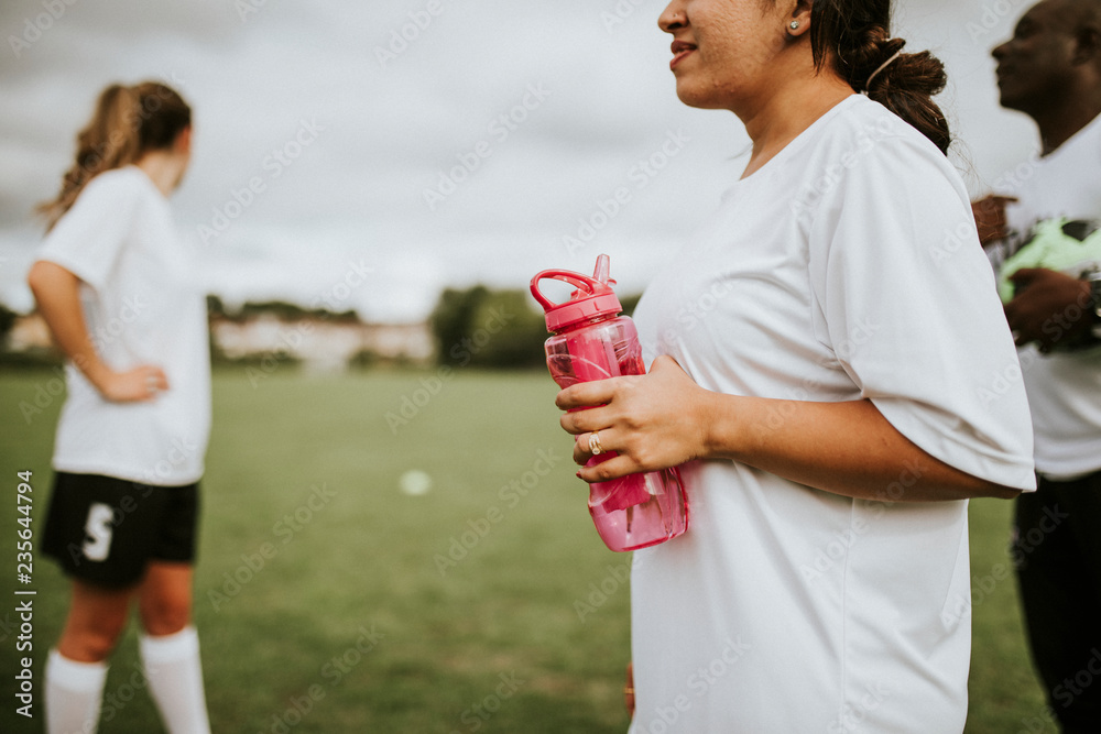 女足球运动员拿着水瓶