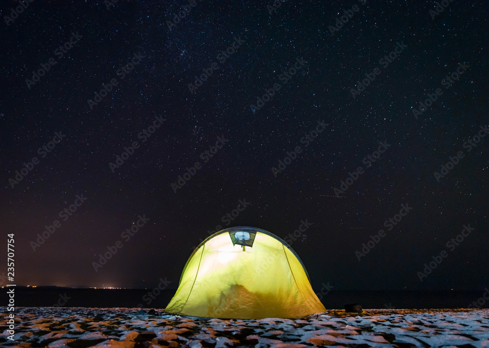 夜晚海滩上的黄色帐篷
