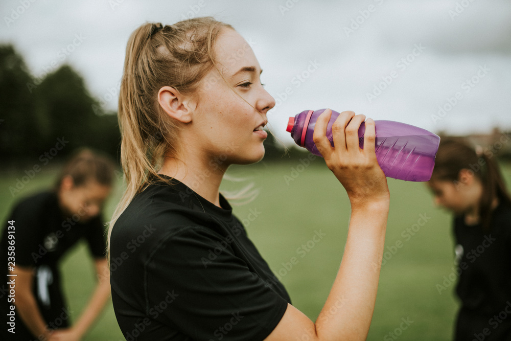 女足球运动员用水瓶喝水