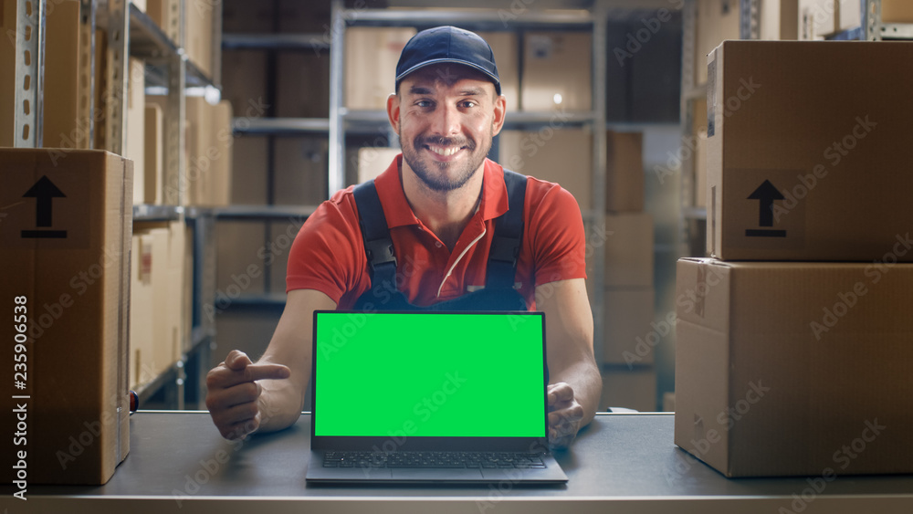 快乐的工人指着笔记本电脑，竖起大拇指，用绿色实体屏幕显示笔记本电脑。