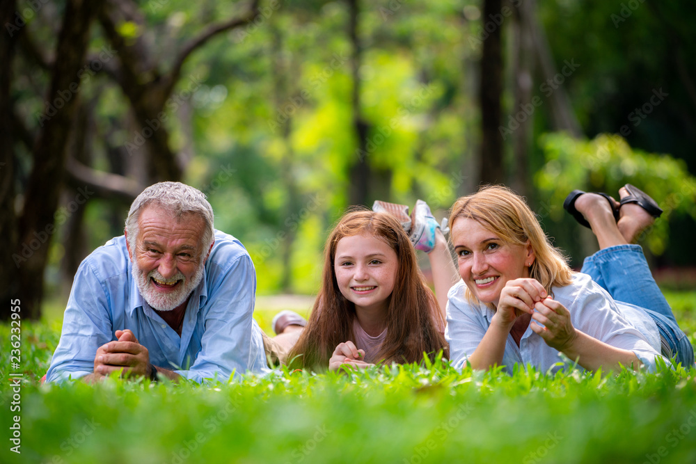 快乐的一家人在夏天一起在公园放松。家庭纽带和关系的概念。