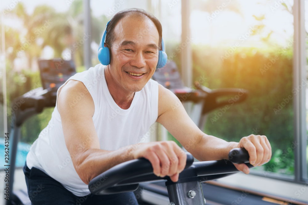 老年人在健身中心骑自行车锻炼。成熟健康的生活方式。