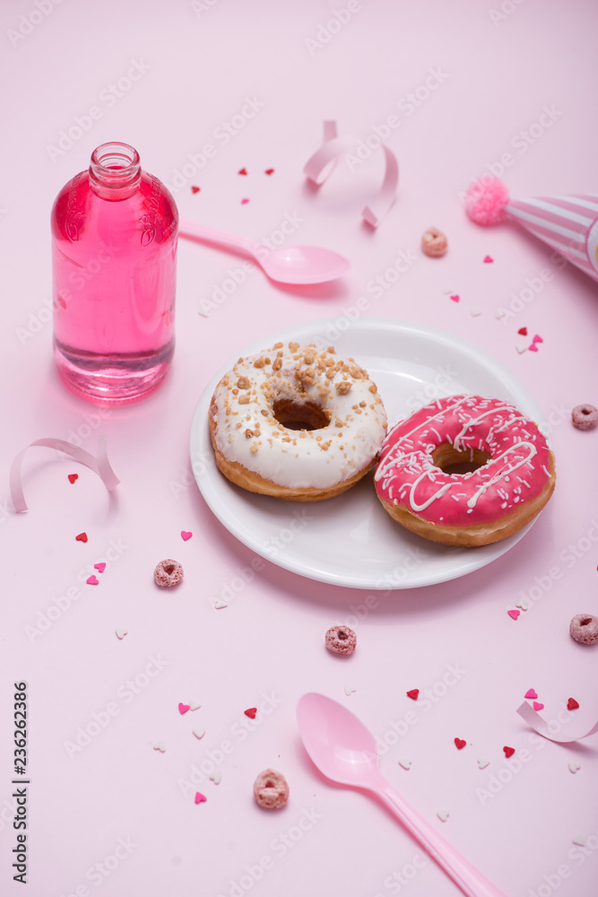 Colorful round donuts on pink background. Flat lay, top view.
