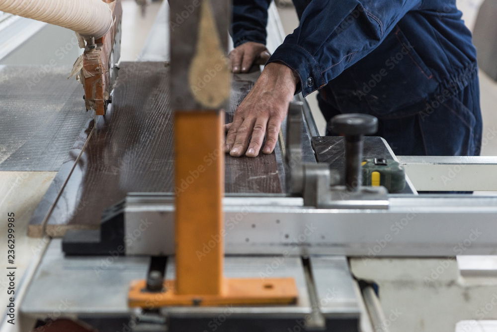 家具生产或工艺概念：工人用特殊材料制作家具部件的木质表面