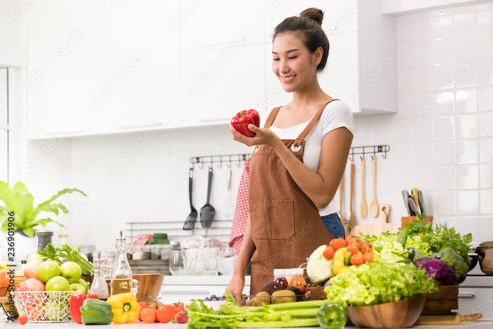 亚洲妇女在厨房里为健康膳食和沙拉准备水果和蔬菜