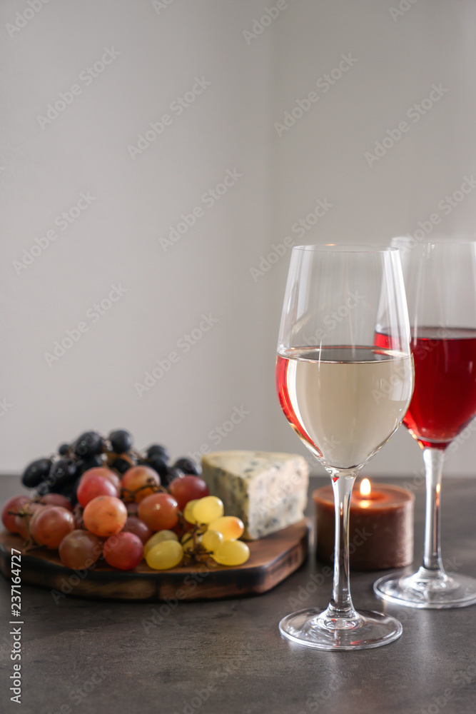灰色桌子上摆着不同种类的葡萄酒和小吃的玻璃杯