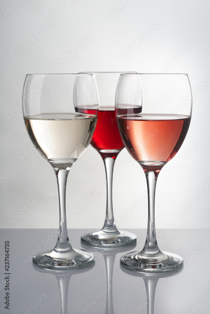 灰色桌子上摆着不同种类葡萄酒的玻璃杯