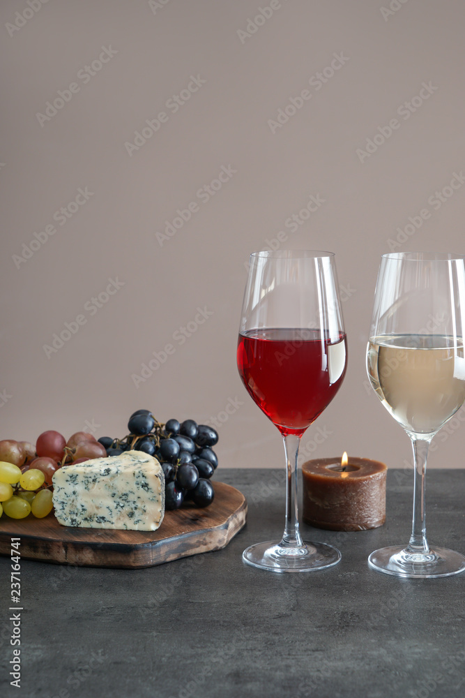 灰色桌子上摆着不同种类的葡萄酒和小吃的玻璃杯