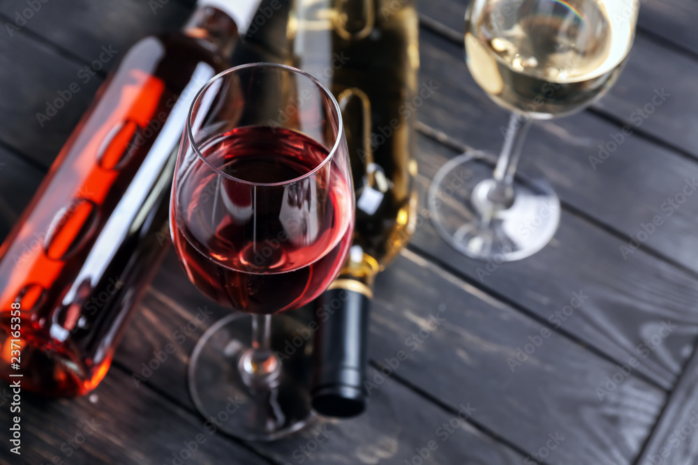 深色木桌上的不同葡萄酒瓶和玻璃杯