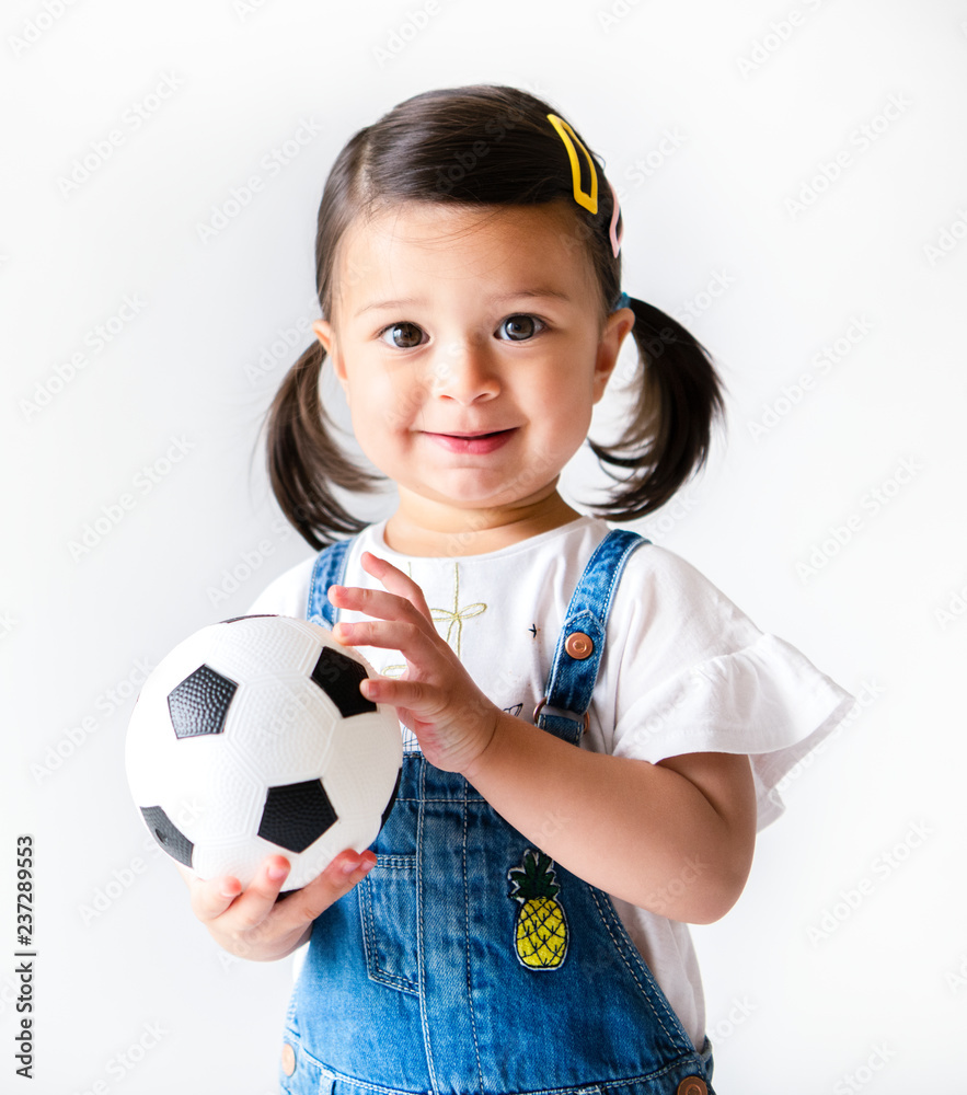 快乐的小女孩拿着足球