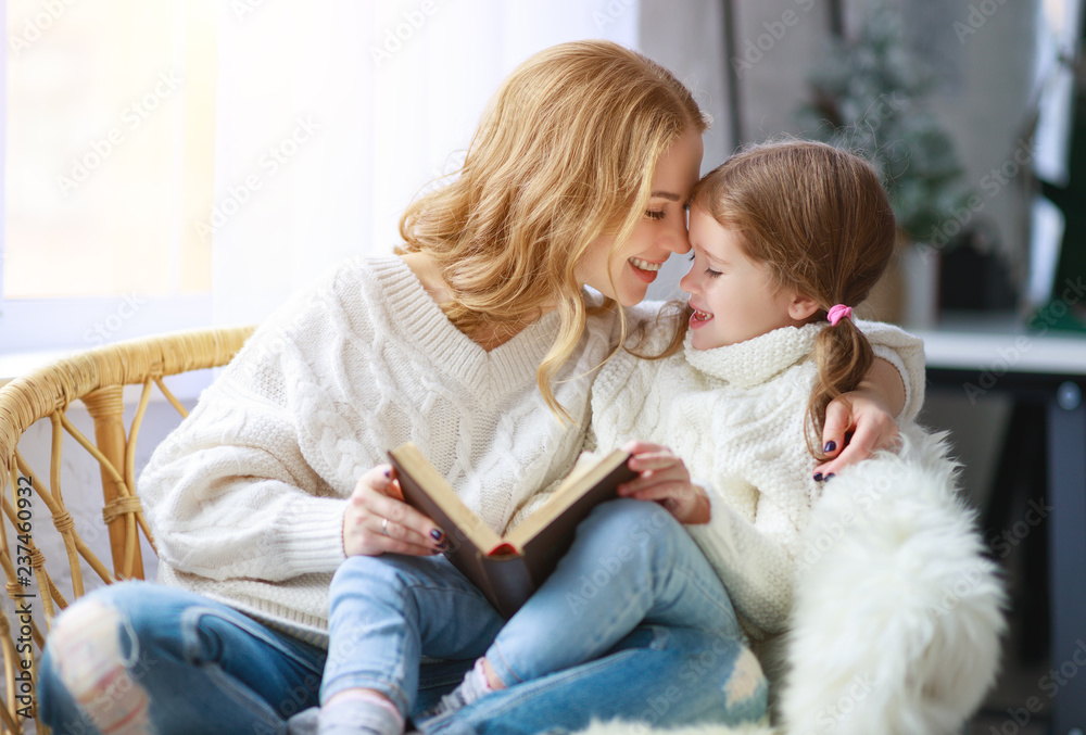 幸福的家庭母亲通过窗户给孩子读书给女儿读