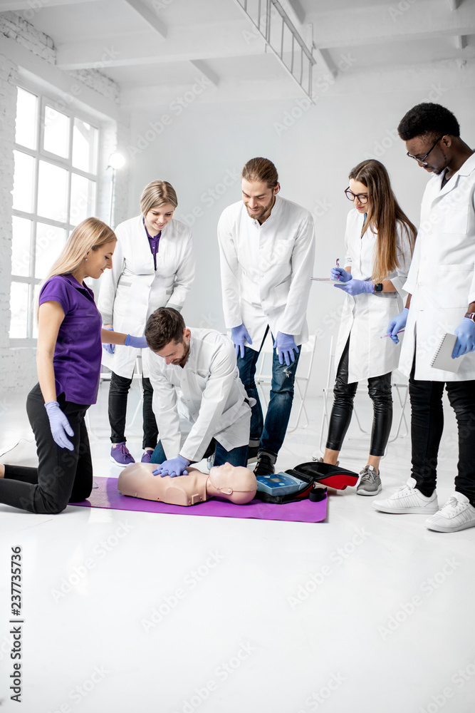 一群年轻的医护人员在第一次练习用医用假人进行人工呼吸